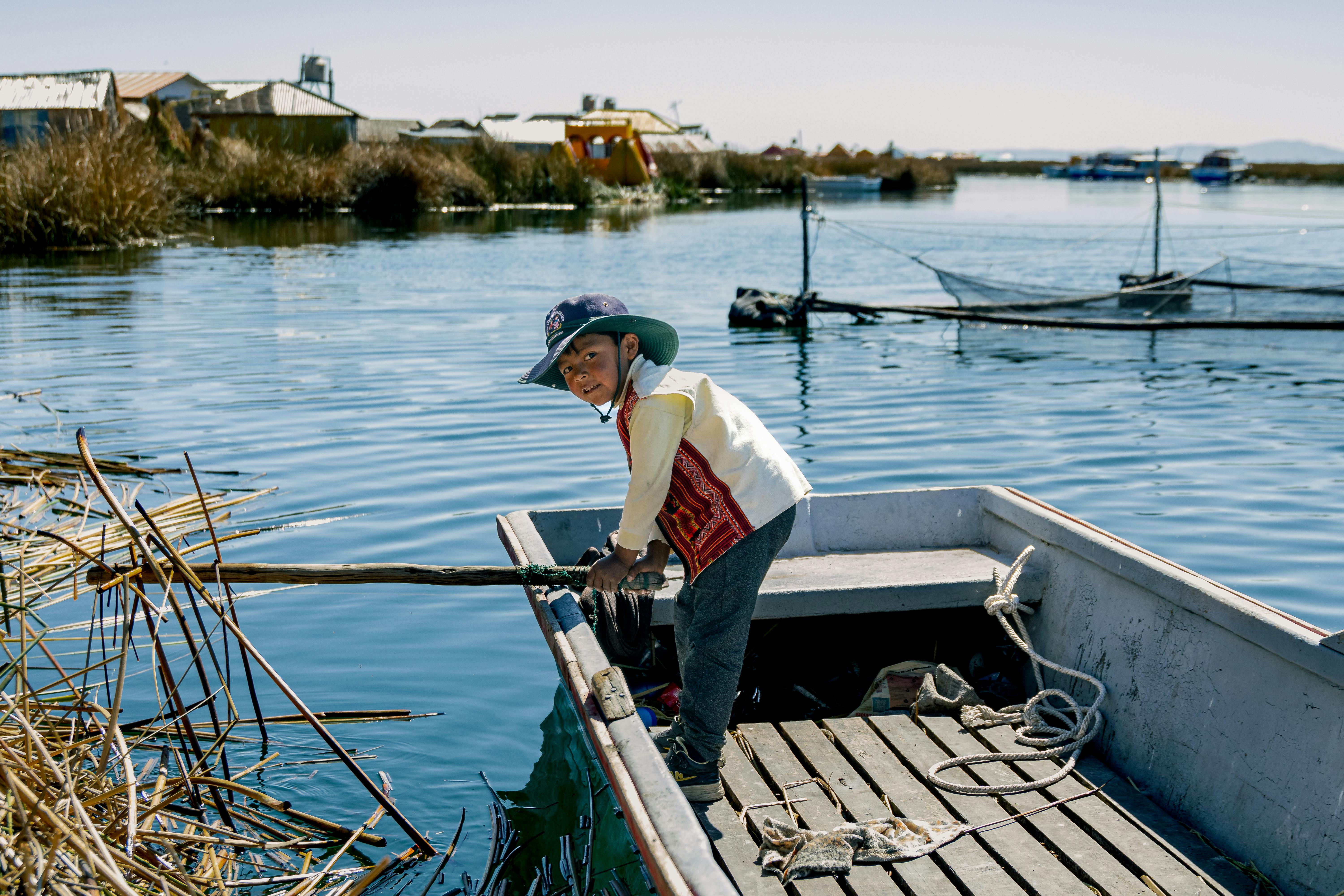 Kid on Boat Playing with Water